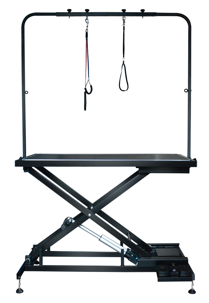 Electric dog grooming table with overhead arm, hanging loops, scissor lift and foot pedals.