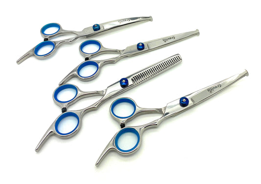 Four types of silver dog grooming scissors with blue finger inserts.