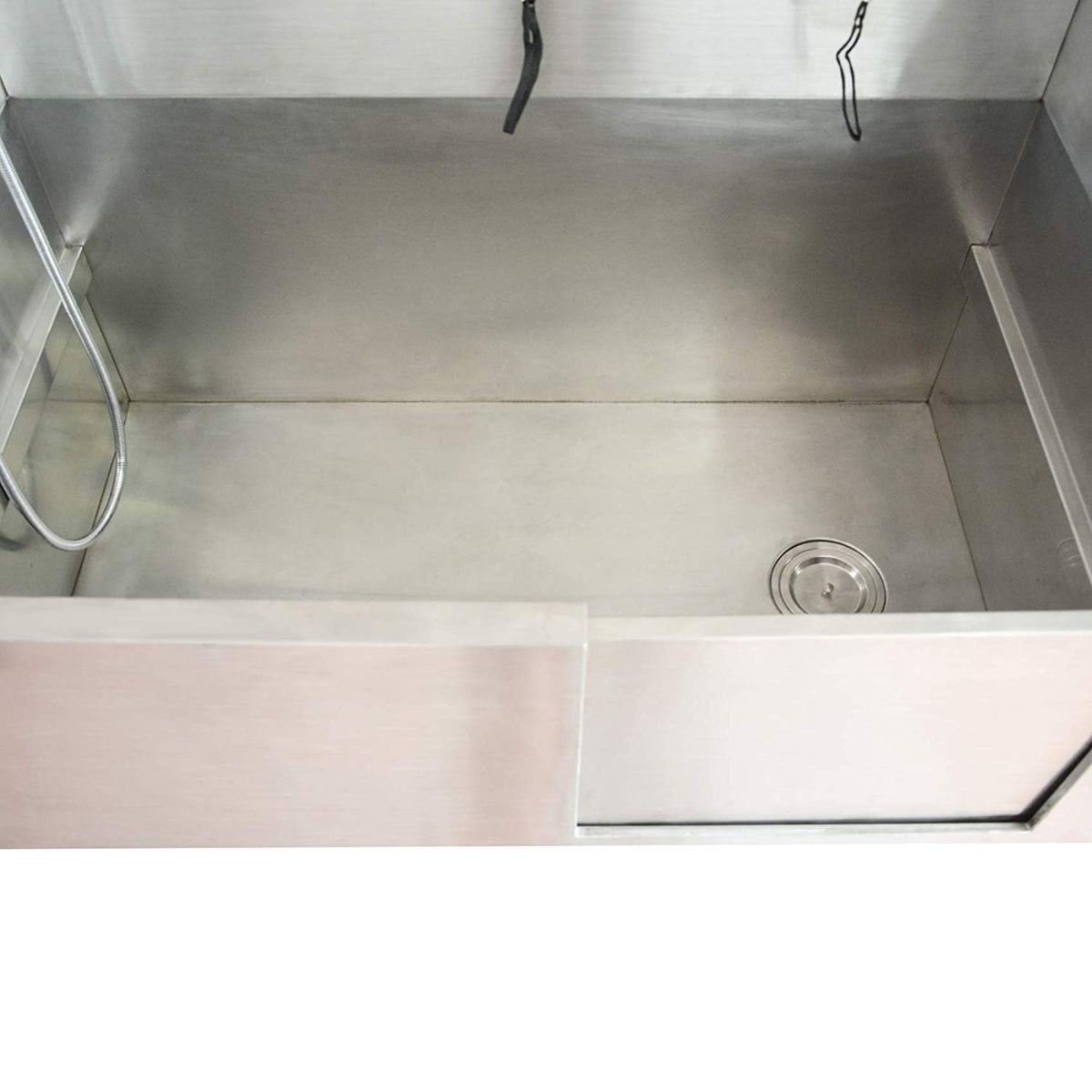 Interior of the stainless steel dog bath showing the basin and drain.
